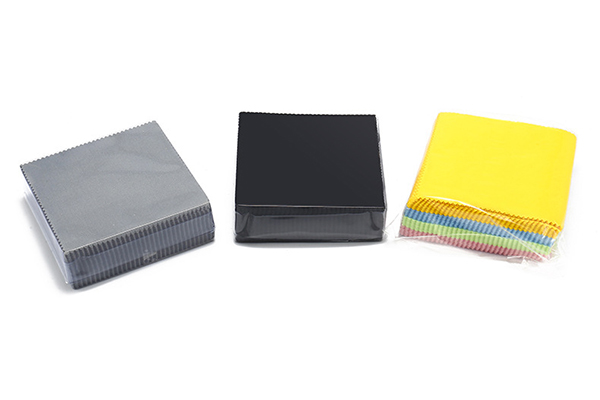 A pair of clean eyeglasses next to a microfiber cloth